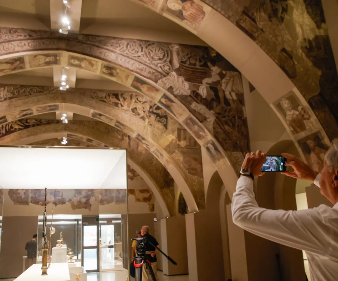 Un hombre fotografía las pinturas murales del Monasterio de Sijena expuestas en el Museu Nacional d’Art de Catalunya (MNAC).Kike Rincon / EP / Archivo