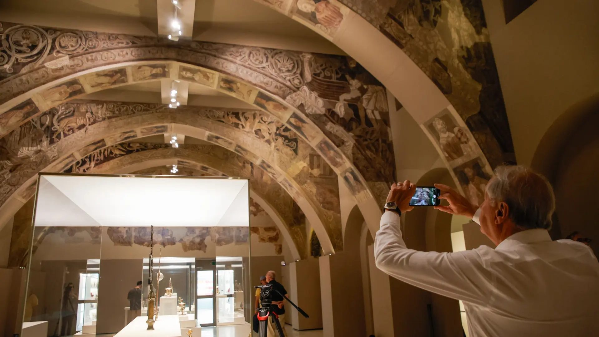 Un hombre fotografía las pinturas murales del Monasterio de Sijena expuestas en el Museu Nacional d’Art de Catalunya (MNAC).Kike Rincon / EP / Archivo