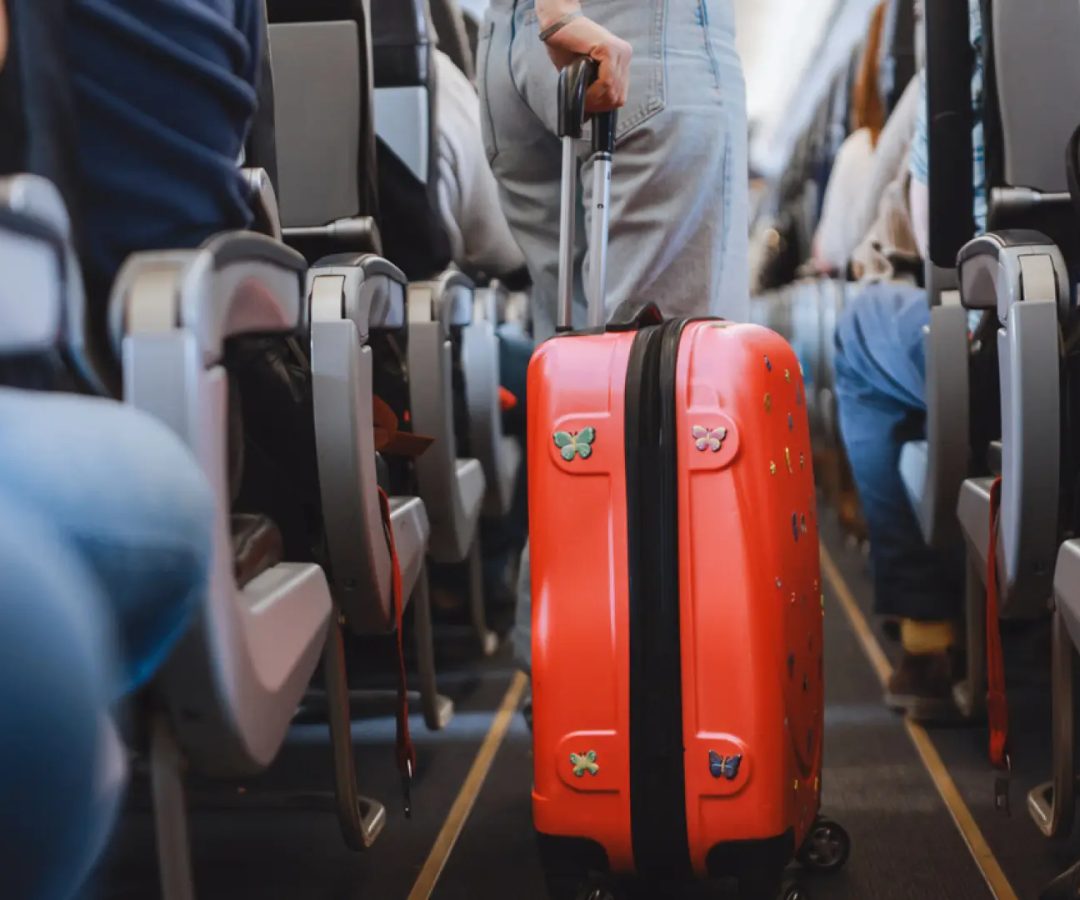 Pasajera con una maleta de cabina en un avión.Getty Images