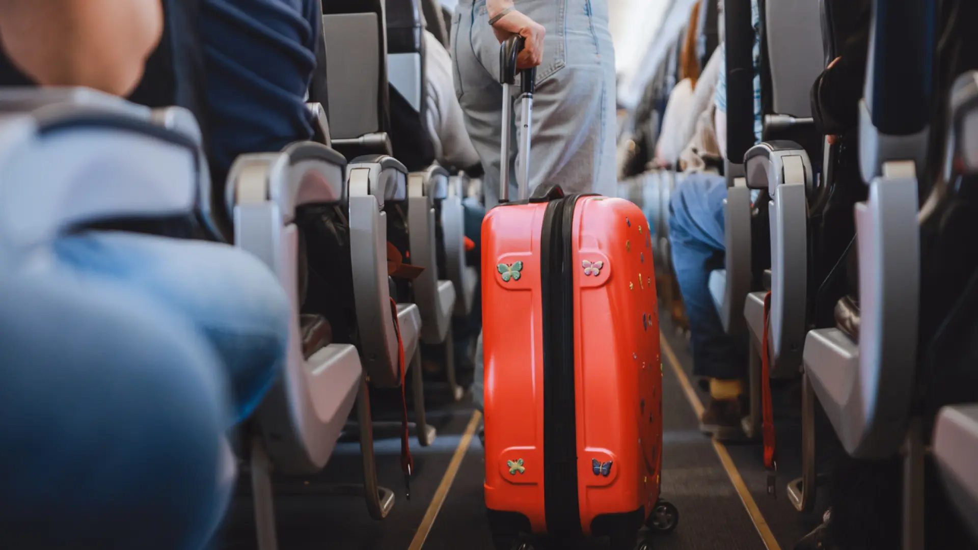 Pasajera con una maleta de cabina en un avión.Getty Images
