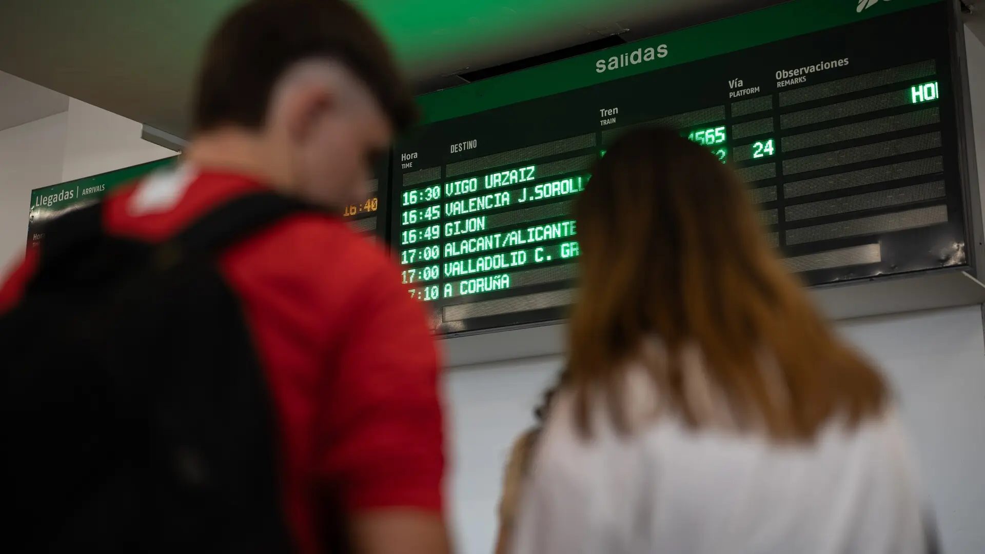 Dos jóvenes esperan para coger un tren en la estación de Chamartín.Alejandro Martínez Vélez - Europa Press
