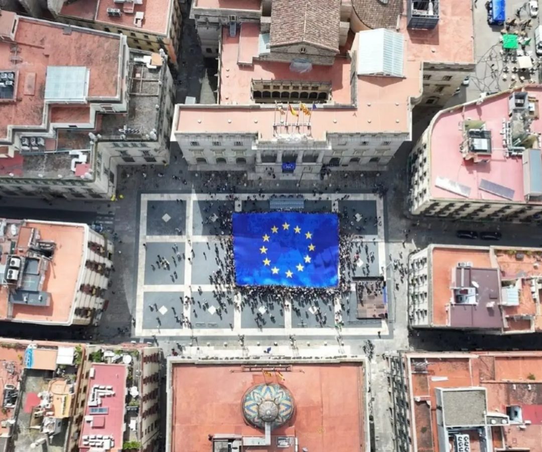 Imagen del despliegue de la bandera de la Unión Europea en la plaza Sant Jaume de Barcelona el 9 de mayo de 2026. Europa Press