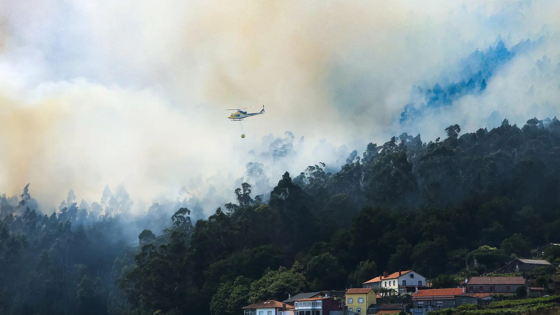 Un helicóptero trabaja en la extinción del incendio de Padrón, en A Coruña, donde se ha declarado la situación 2 de emergencia.EFE