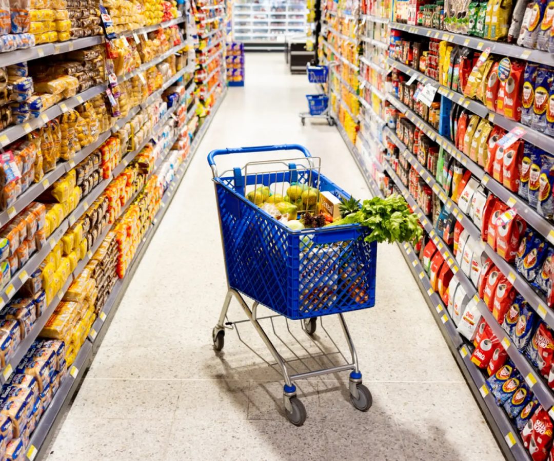 Carrito de compras en el medio en un pasillo del supermercadoGetty Images/iStockphoto