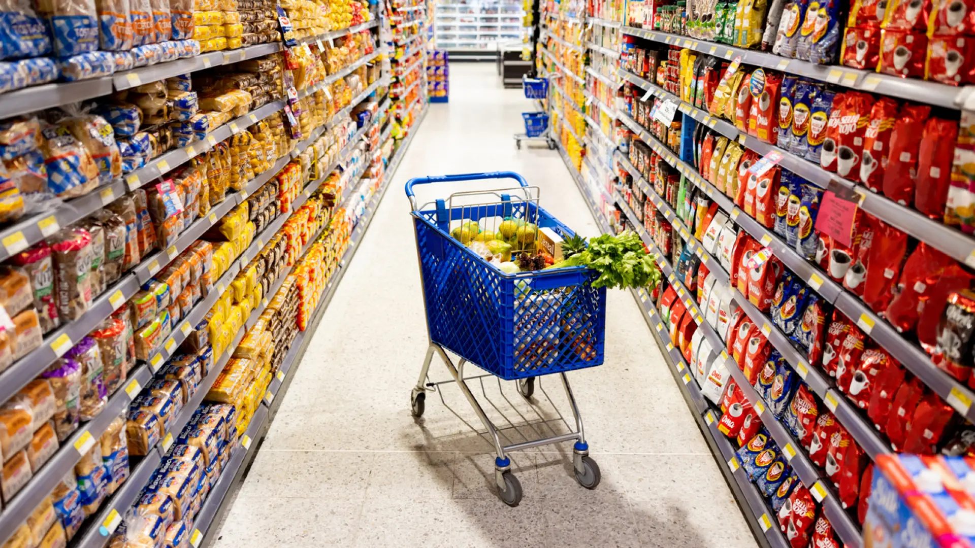 Carrito de compras en el medio en un pasillo del supermercadoGetty Images/iStockphoto