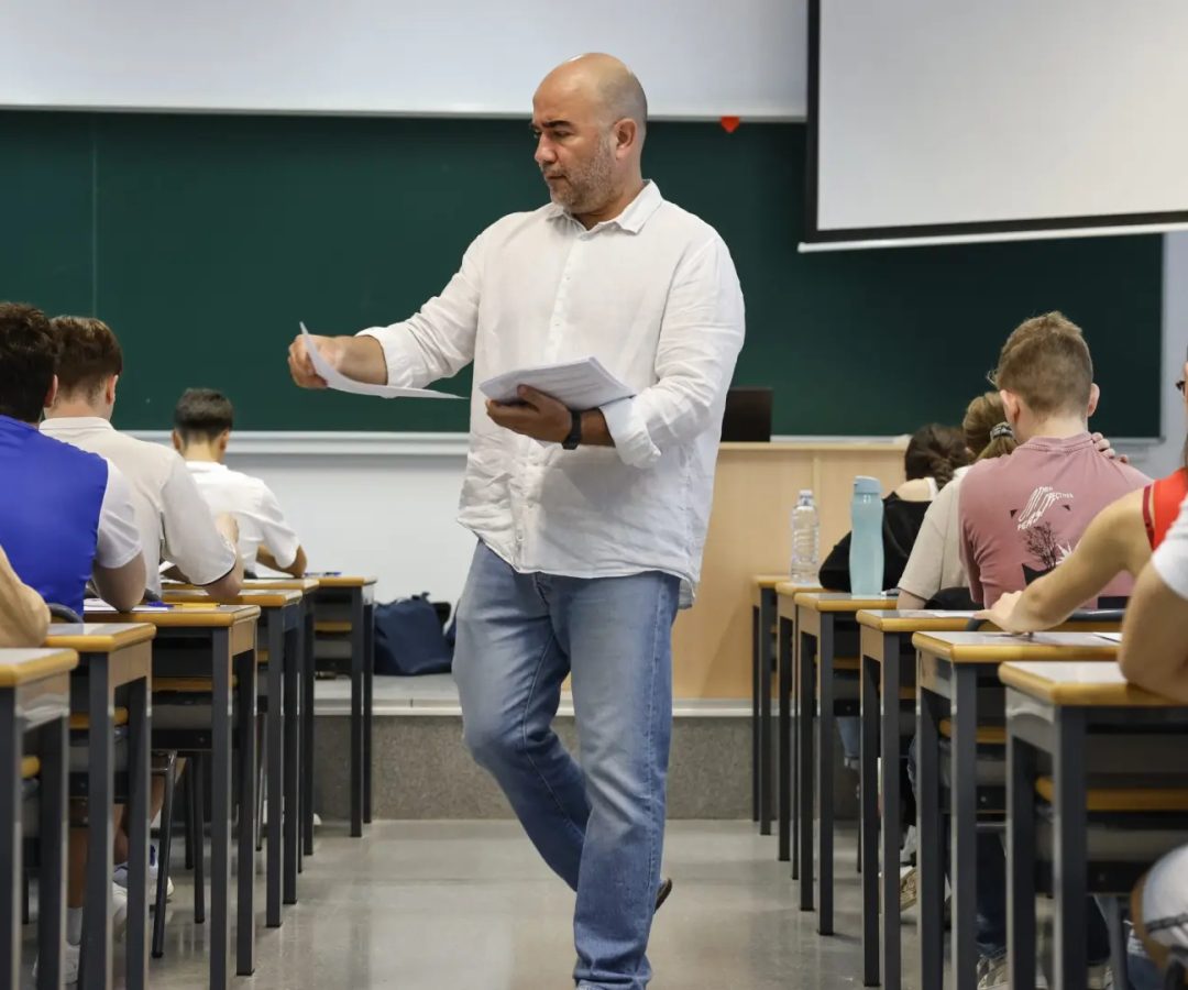 Un docente reparte los exámenes en un aula en Valencia.ANA ESCOBAR / EFE