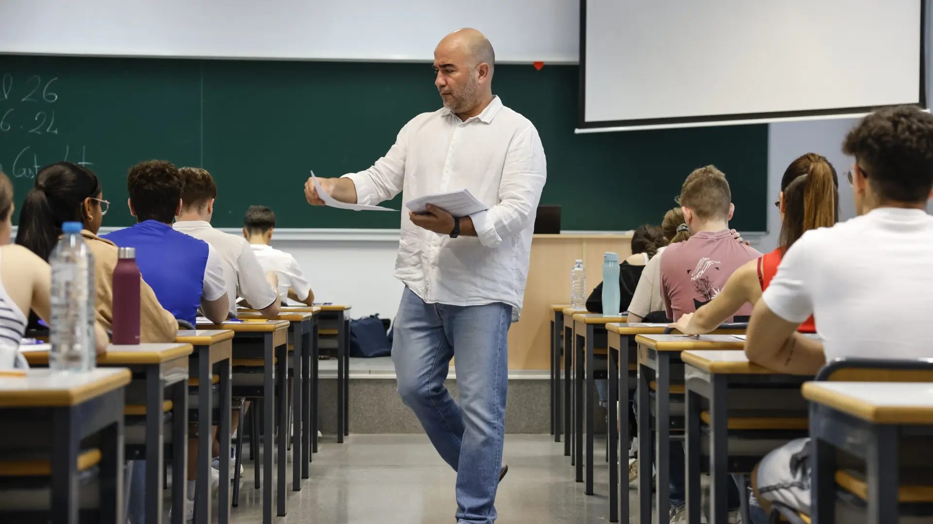 Un docente reparte los exámenes en un aula en Valencia.ANA ESCOBAR / EFE